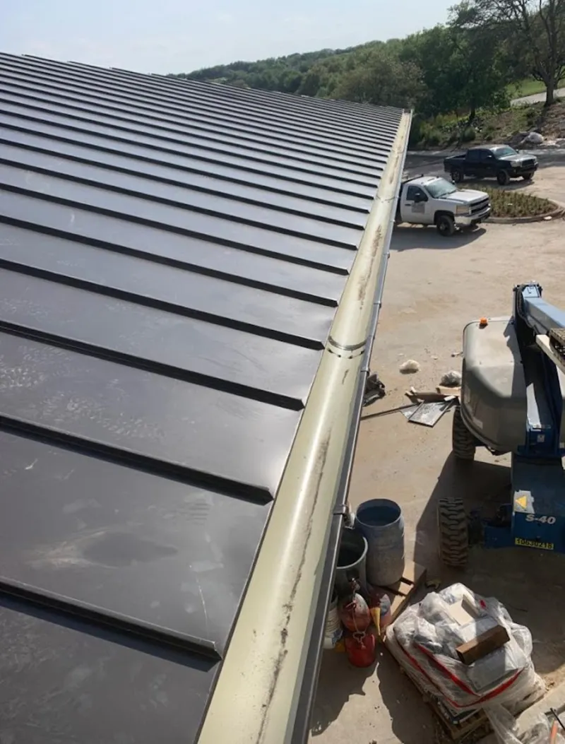 Standing seam panel and gutter detail on a metal roofing jobsite in Waterbury
